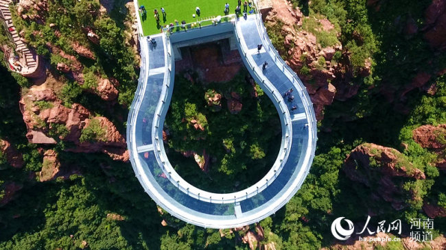 Photo taken on June 12, 2018 shows the world's longest horseshoe-shaped glass bridge at the Fuxi Grand Canyon in central China's Henan Province. [Photo: people.cn]