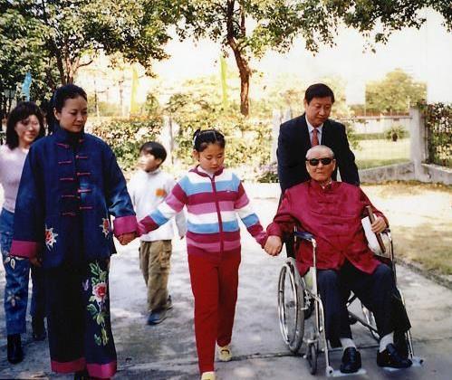 One of the photos on the bookshelf in President Xi Jinping's office shows him taking his father in a wheelchair for a walk along with his wife Peng Liyuan and their daughter. [Photo: Photographs of Xi Zhongxun]