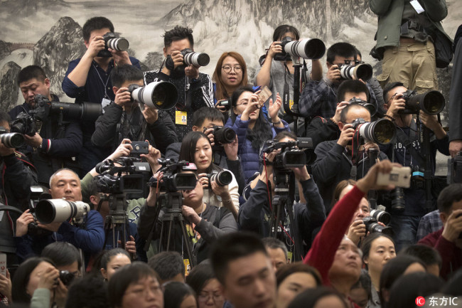 Journalists take photos during a press conference by Wang Guoqing, spokesperson for the Chinese People's Political Consultative Conference (CPPCC), at the Great Hall of the People in Beijing, March 2, 2018. [Photo: IC]