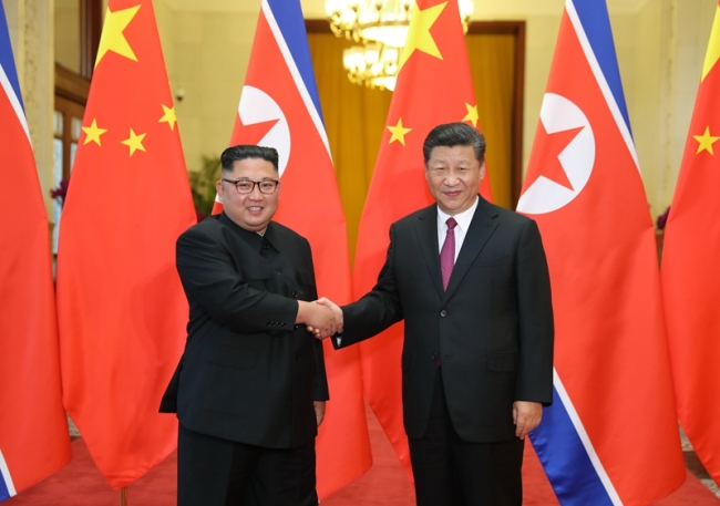 Xi Jinping (R), general secretary of the Central Committee of the Communist Party of China and Chinese president, shakes hands with Kim Jong Un, chairman of the Workers' Party of Korea and chairman of the State Affairs Commission of the Democratic People's Republic of Korea (DPRK), in Beijing on Tuesday, June 19, 2018. [Photo: Xinhua]