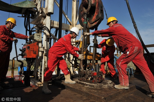 Crude oil workers work at the oil field in the Xinjiang Uygur Autonomous Region on August 16, 2012. [File Photo: VCG]