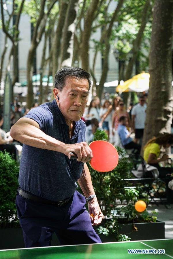 Baolong Huang plays ping pong at Bryant Park in New York, the United States on June 19, 2018. [Photo: Xinhua/Lin Bilin]