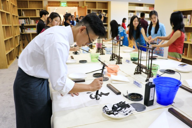 A Myanmar practices Chinese calligraphy at the China Cultural Center in Yangon, Myanmar, on July 7, 2018. [Photo: China Plus/Tu Yun]