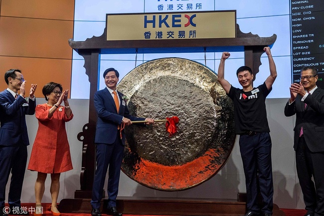 Xiaomi founder, chairman and CEO, Lei Jun (3rd L), hits a gong at the company's initial public offering (IPO) launch on the Hong Kong Stock Exchange in Hong Kong on July 9, 2018. [Photo: VCG]