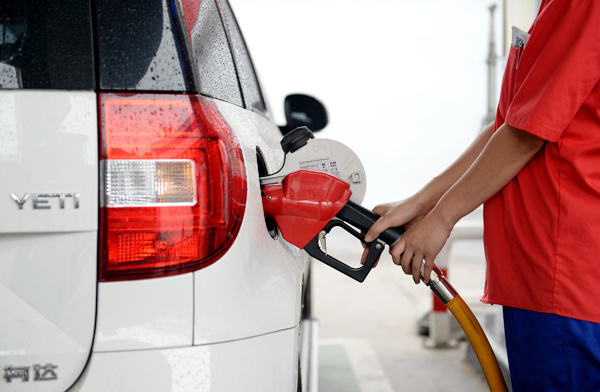 A worker fills up a car with fuel at a gas station in Xi'an city, Shaanxi province, June 9, 2017. [Photo: Xinhua]