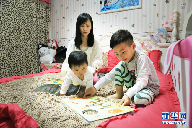 A mother of two children tells a bedtime story to her children in Shanghai, China, May 4, 2016. [File photo: Xinhua]