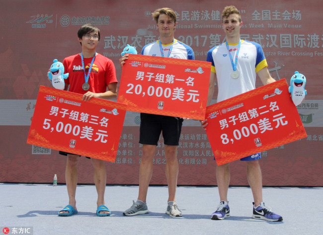 Winners of the 44th Wuhan International Yangtze River Crossing Festival stand on awarding podium on July 16, 2018. [Photo: IC]