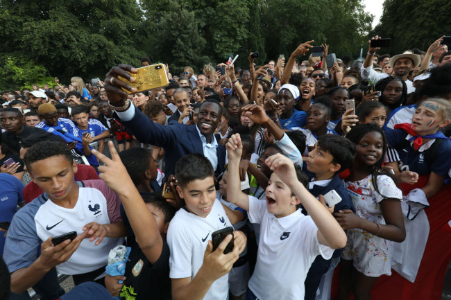 France's defender Benjamin Mendy (C) takes a selfie with supporters during a reception at the Elysee Presidential Palace on July 16, 2018 in Paris, after French players won the Russia 2018 World Cup final football match. [Photo: AFP/Ludovic MARIN]