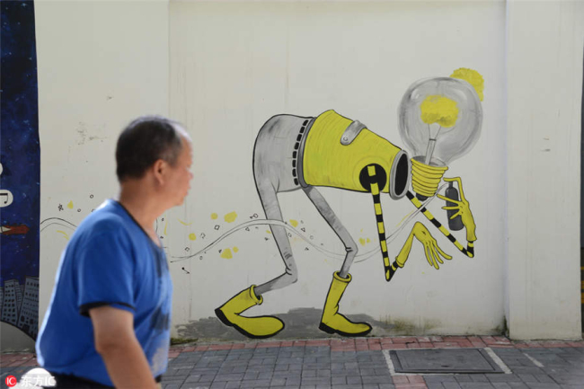 A pedestrian walks past a street mural in Guiyang city, Southwest China's Guizhou province, July 29, 2018. [Photo/IC]