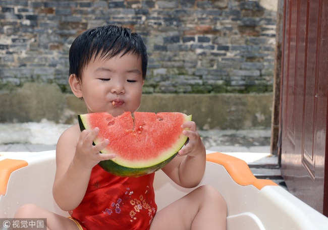 A child eats a piece of watermelon to mark the Start of Autumn.[File Photo: VCG]