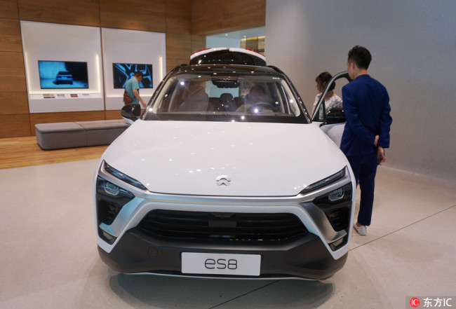 Visitors inspect and test the NIO ES8 electric SUV on display at the company's flagship store in Hangzhou, Zhejiang province, August 14, 2018.[Photo: IC]