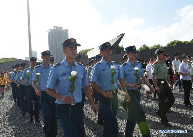 Military personnel lay flowers at The Memorial Hall of the Victims in Nanjing Massacre by Japanese Invaders in east China's Jiangsu Province, Aug. 15, 2018.