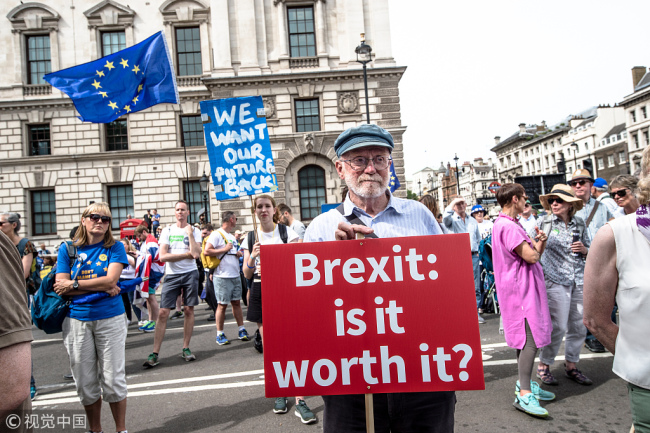 A man holding a pro-Eu poster in London, June 23, 2018. A coalition of pro-EU groups organized a march to parliament to demand a Peoples Vote on Brexit deal and whatever the government proposes on its future relationship with the EU. [File Photo: VCG]