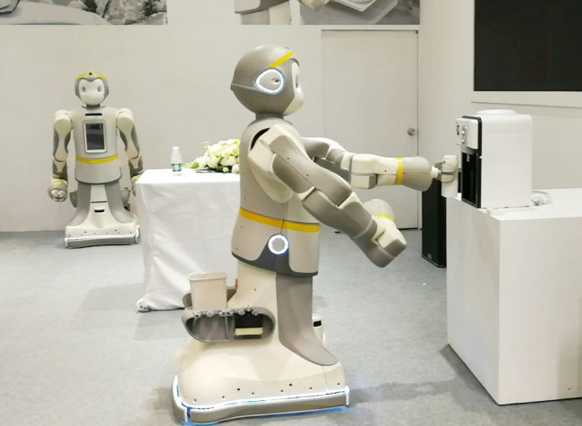 A "P-Care" robot serves water. [Photo: China Plus]