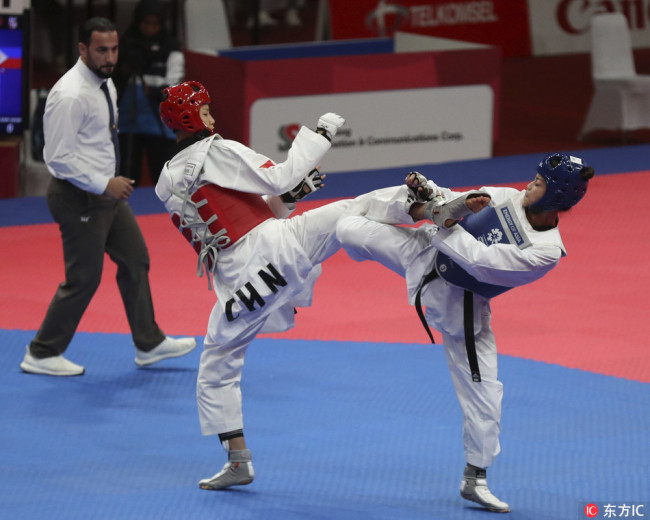 China's Zongshi Luo, left, competes against Philippine's Pauline Louise Lopez during their women's -57 kilogram Taekwondo semifinals match at the 18th Asian Games in Jakarta, Indonesia, Tuesday, Aug. 21, 2018.[Photo: IC]