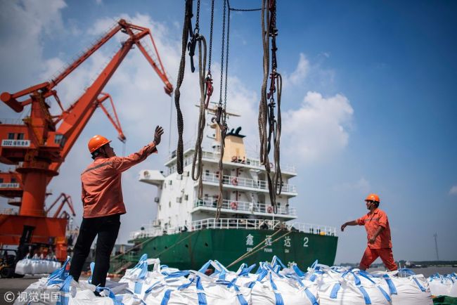 This file picture taken on August 7, 2018 shows workers unloading bags of chemicals at a port in Zhangjiagang in China's eastern Jiangsu province. [Photo: VCG]