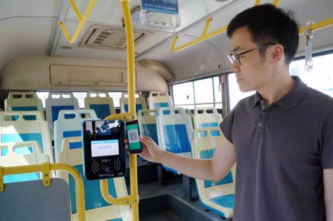 A passenger uses his smartphone to scan a QR code to pay his bus fare in the Beijing suburbs on Wednesday, September 12, 2018. [Photo: Beijing Morning Post]