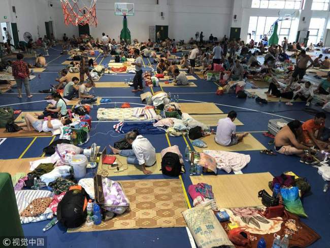 Evacuees gather at temporary shelter in a basketball gym at a primary school in Zhuhai, Guangdong Province, September 16, 2018. [Photo: VCG]