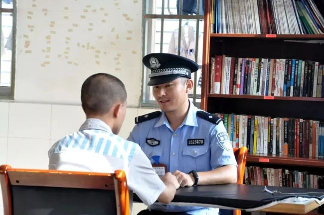 A prisoner signs a note agreeing to the terms of his prison leave before going on a family visit during Mid-Autumn Festival. [Photo: thepaper.cn]