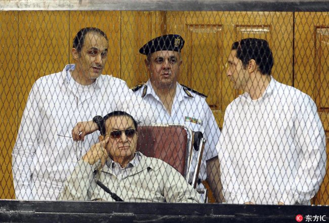 In this Sept. 14, 2013 file, former Egyptian President Hosni Mubarak, seated, and his two sons Gamal Mubarak, left, and Alaa Mubarak, right, attend a hearing in a courtroom at the Police Academy, Cairo, Egypt. [Photo: IC]