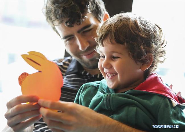 A man and his son make paper puppet of Jade Rabbit during the Mid-Autumn Moon Family Festival event held at the Museum of Chinese in America (MOCA) in New York, the United States, Sept. 22, 2018. [Photo: Xinhua]  