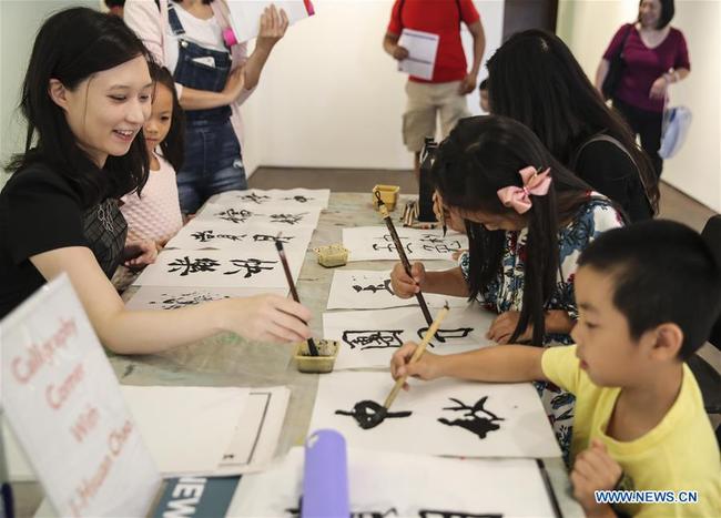 Children practice Chinese calligraphy during the Mid-Autumn Moon Family Festival event held at the Museum of Chinese in America (MOCA) in New York, the United States, Sept. 22, 2018. [Photo: Xinhua] 