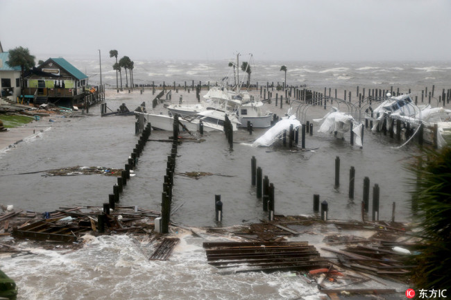 Storm Surge retreats from inland areas, foreground, where boats lay sunk and damaged at the Port St. Joe Marina in the Florida Panhandle on Wednesday after Hurricane Michael made landfall near Mexico Beach. [Photo: IC]