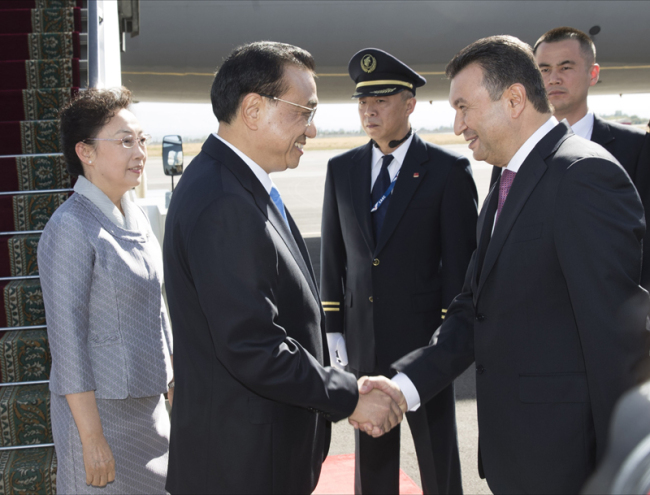 Chinese Premier Li Keqiang shakes hands with Tajikistan Prime Minister Kokhir Rasulzoda as he arrives at the Dushanbe international airport on Thursday, October 11, 2018. [Photo: gov.cn]