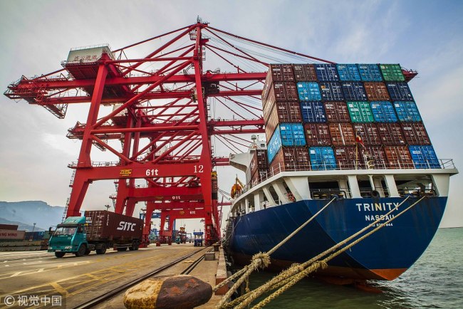 A cargo ship unloads good at a container terminal of Lianyungang Port, Jiangsu province. [File Photo: VCG]