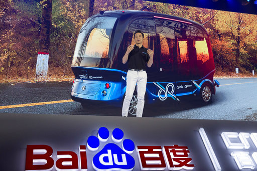 Robin Li, CEO of search giant Baidu, speaks near an image of the Apolong, China's first L4 fully autonomous bus, during the Baidu Create 2018 held in Beijing, China, Wednesday, July 4, 2018. The event seeks to connect developers, businesses and individuals to the AI resources of the Chinese search company. [Photo: AP/Ng Han Guan]