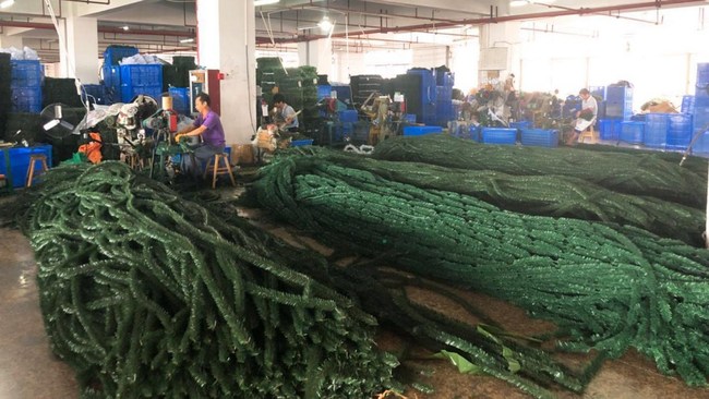 Workers produce Christmas trees in a factory in Yiwu, September 26, 2018. [Photo: CGTN]