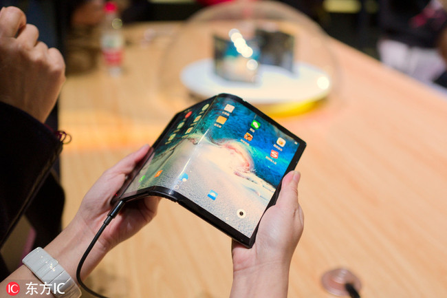 Customers try out the large-screen foldable devices launched by Royole Corp, a manufacturer of flexible displays and smart devices, during a press conference in Beijng, China, October 31.[Photo: IC]