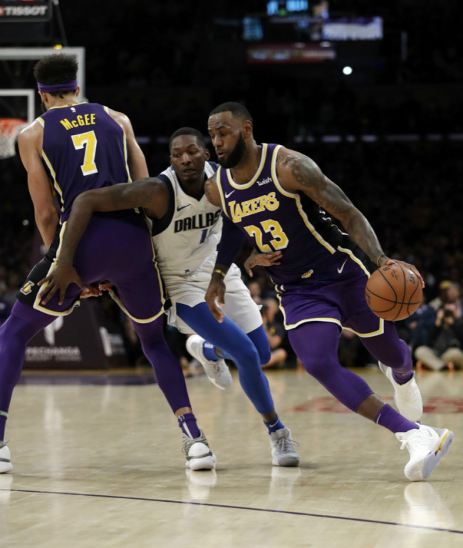 Los Angeles Lakers' LeBron James (23) dribbles around Dallas Mavericks' Dorian Finney-Smith, center, as JaVale McGee (7) sets a screen during the second half of an NBA game on Wednesday, October 31, 2018, in Los Angeles. [Photo: AP]