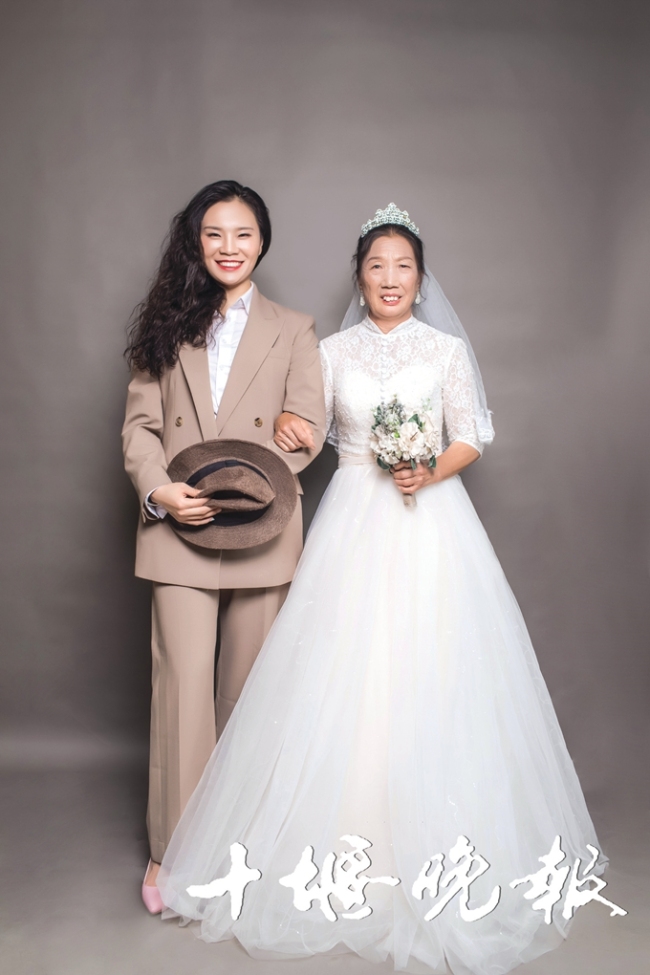 28-year-old Ma Er poses for the wedding photo with her widowed mother, Sept. 20, 2018. [Photo: Shiyan Evening News]