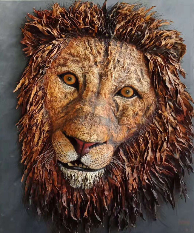 Chinese artist Zhou Jianqian creates a hunted lion, an oil painting using old newspapers. [Photo:China Daily]