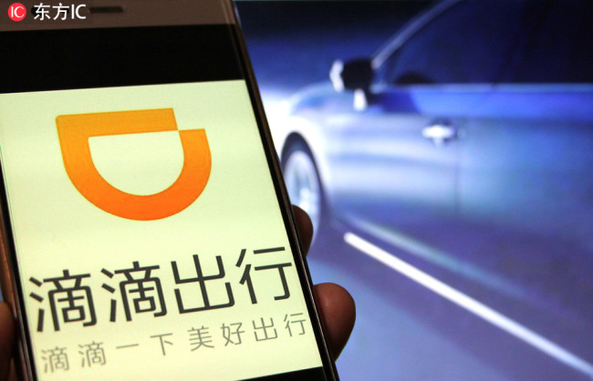 A Chinese mobile phone user uses the mobile app of taxi-hailing and car service Didi Chuxing on his smartphone in Huaibei city, east China's Anhui province, September 5, 2018. [Photo: IC]