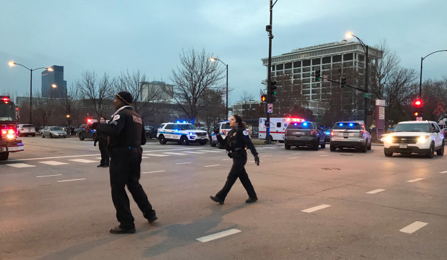 Chicago Police officers walk outside Mercy Hospital on the city's South Side where authorities say a shooting at the hospital has wounded multiple people, including a suspect and a police officer, Monday, Nov. 19, 2018, in Chicago. [Photo: AP]