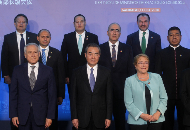 (Front L-R) Chile's Foreign Minister Heraldo Munoz, China's Foreign Minister Wang Yi and Chilean President Michelle Bachelet pose for the family picture of the Second Ministerial Meeting of the Forum of China and the Community of Latin American and Caribbean States (China-CELAC) in Santiago, on January 22, 2018. [Photo: AFP/CLAUDIO REYES]
