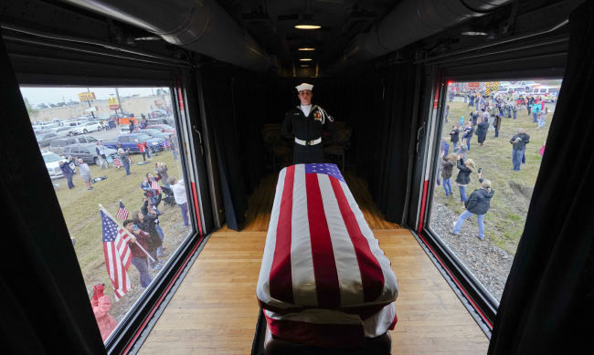 The flag-draped casket of former President George H.W. Bush passes through Magnolia, Texas, Thursday, Dec. 6, 2018, along the route from Spring to College Station, Texas. [Photo: AP/David J. Phillip]