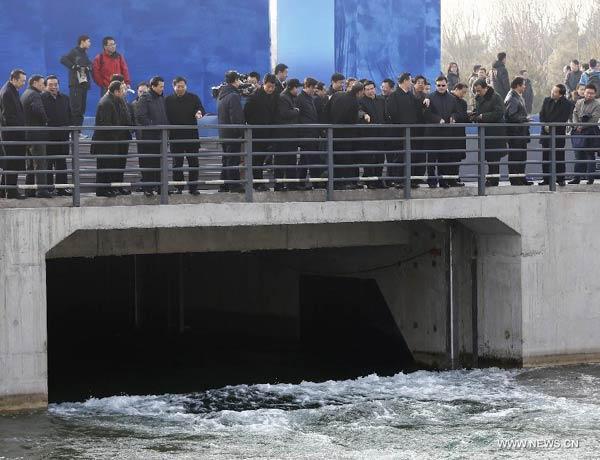 People watch the opening of a sluice gate of the middle route of the south-to-north water diversion project in Beijing, capital of China, Dec 27, 2014.[Photp:Xinhua]