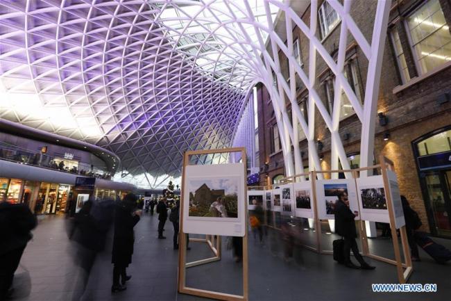 Passengers view a photography exhibition at London's Kings Cross Station in London, Britain, Dec. 10, 2018. [Photo: Xinhua]