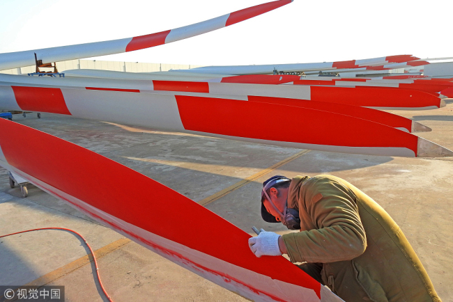 On Friday, December 14, 2018 in the Economic and Technological Development Zone of Lianyungang City, Jiangsu Province, workers undertake quality checks of wind turbine blades before they leave the factory. [Photo: VCG]