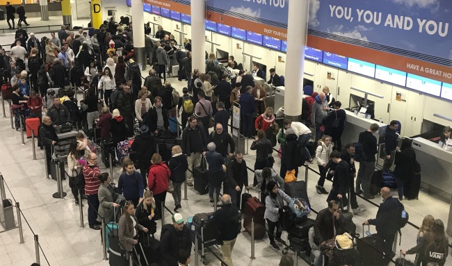 Passengers wait to check in at Gatwick Airport in England, Friday, Dec. 21, 2018. [Photo: AP]
