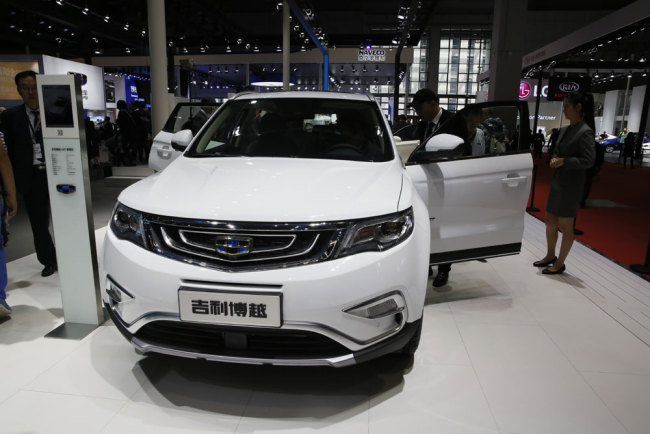 A visitor looks at a SUV from Chinese automaker Geely during the Auto Shanghai 2017 show at the National Exhibition and Convention Center in Shanghai, China, Wednesday, April 19, 2017. Models on display at Auto Shanghai 2017, the global industry's biggest marketing event of the year, reflect the conflict between Beijing's ambitions to promote environmentally friendly propulsion and Chinese consumers' love of hulking, fuel-hungry SUVs. [Photo: AP]