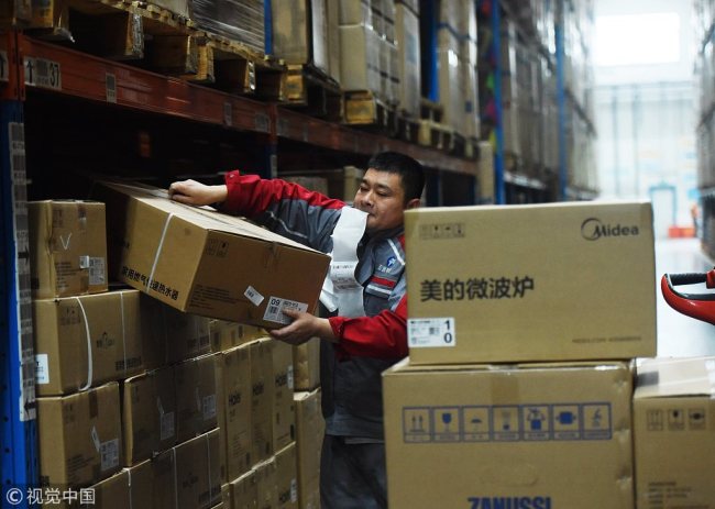 A courier sorts parcels at a warehouse in Hangzhou, Zhejiang Province on November 12, 2018. [Photo: VCG]