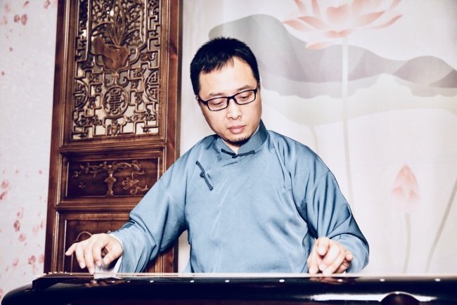 Zhang Xuguang, a musician with the China Broadcasting Chinese Orchestra is playing the guqin. [Photo Courtesy of: Zhang Xuguang]