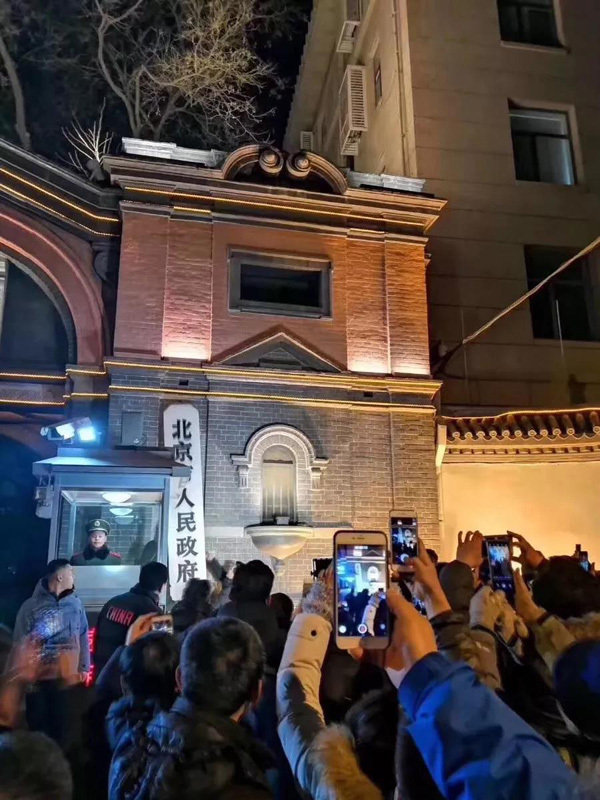 Residents take pictures of the original plaque of Beijing Municipal Government as it is removed from the government offices’ former site and sent to the Beijing Municipal Archives for storage on Jan 10, 2019. [Photo: CCTV]
