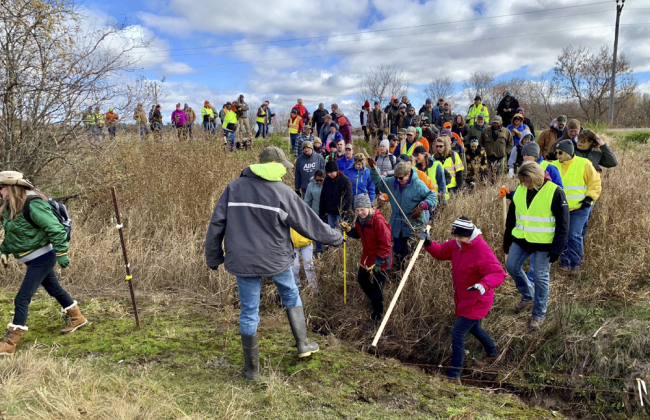 In this Oct. 23, 2018, file photo, volunteers cross a creek and barbed wire near Barron, Wis., on their way to a ground search for 13-year-old Jayme Closs who was discovered missing Oct. 15 after her parents were found fatally shot at their home. [File photo: AP/Jeff Baenen]