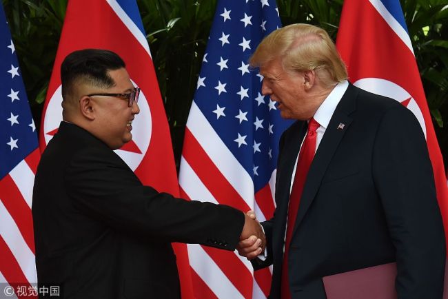 North Korea's leader Kim Jong Un (L) shakes hands with US President Donald Trump (R) after taking part in a signing ceremony at the end of their historic US-North Korea summit, at the Capella Hotel on Sentosa island in Singapore on June 12, 2018. [File Photo; VCG]