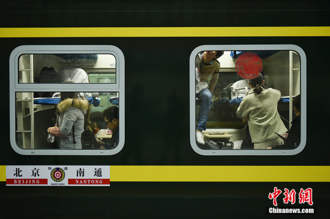 Passengers(旅客 lǚkè) seen from the window(窗户 chuānghù) of a train(列车 lièchē) at Beijing Railway Station on Jan 21, 2019.[Photo/Chinanews.com]